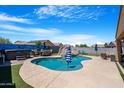 Sparkling in-ground pool with waterfall feature, slide, and hot tub at 37460 W Giallo Ln, Maricopa, AZ 85138
