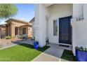 Welcoming front porch with artificial turf, decorative blue planters, and a cozy entrance to the home at 389 W Fairway Pl, Chandler, AZ 85225