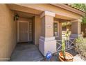 Inviting covered front porch with security door, potted cactus and views of desert landscaping at 43813 W Rio Lobo Dr, Maricopa, AZ 85138