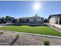 Landscaped front yard featuring artificial turf, decorative rock, and a charming brick house at 514 N 74Th St, Scottsdale, AZ 85257