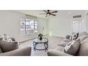 Cozy living area with a window view, ceiling fan, stylish sofas, and tile floors at 5827 N 22Nd Dr, Phoenix, AZ 85015