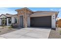 Front view of a charming single-Gathering home with a gray garage door and desert landscaping at 7421 S 76Th Ln, Laveen, AZ 85339
