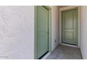 Hallway with two green interior doors and textured white walls at 7421 S 76Th Ln, Laveen, AZ 85339