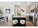 Modern kitchen showcasing gray cabinets, a center island, and stainless steel appliances at 7454 S 75Th Dr, Laveen, AZ 85339