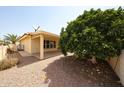 Private backyard with mature trees providing shade, gravel ground cover, and covered patio at 8303 E Monterey Ave, Mesa, AZ 85209