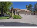 Landscaped home with three car garage, tile roof, and private entry gate at 9412 S Palm Dr, Tempe, AZ 85284