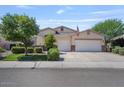 Traditional-style home featuring a manicured lawn, mature trees, and a convenient three-car garage at 1145 E Winchester Pl, Chandler, AZ 85286