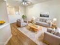 Bright and inviting living room with modern furniture, a ceiling fan, and wood flooring at 13106 W Calavar Rd, Surprise, AZ 85379