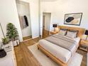 Bright main bedroom with hardwood floors, a walk-in closet, and modern décor at 13106 W Calavar Rd, Surprise, AZ 85379