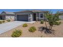 View of the inviting single-story home, with a two-car garage and desert landscaping at 1560 E Squire Dr, Casa Grande, AZ 85122