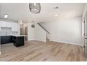 Bright living room with wood floors, staircase, stylish lighting, and seamless transition to the kitchen area at 1718 W Colter St # 142, Phoenix, AZ 85015