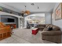 Bright and spacious living room featuring neutral colors, tile and carpet flooring, and comfortable seating arrangements at 18066 W Weatherby Dr, Surprise, AZ 85374