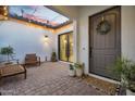 Private courtyard boasts a stylish brick floor, comfortable seating, and a welcoming entryway at 19428 S 210Th Pl, Queen Creek, AZ 85142