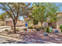 Charming single Gathering home, desert landscape, and lush mature trees in the front yard at 21050 E Munoz St, Queen Creek, AZ 85142