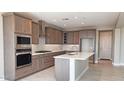 A modern kitchen features stainless steel appliances, a central island, and lots of storage inside wood finish cabinetry at 4227 W Adobe Dr, Eloy, AZ 85131