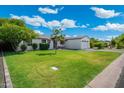 Well-manicured lawn and charming single-story home with a paved driveway at 4842 E Fairmount Ave, Phoenix, AZ 85018