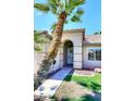 Charming arched front entryway to home featuring a decorative glass door, complemented by mature landscaping at 705 W Country Estates Ave, Gilbert, AZ 85233