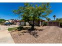 View of home showing brick driveway, mature tree, and partial view of front facade with gated motor court at 7403 W Montebello Ave, Glendale, AZ 85303