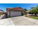 Low angle showcasing home's terracotta tile roof, two car garage, stucco, and partially landscaped yard at 7403 W Montebello Ave, Glendale, AZ 85303