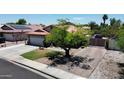 Charming single-Gathering home with a well-manicured lawn, mature tree, brick driveway, and fenced entry at 7403 W Montebello Ave, Glendale, AZ 85303