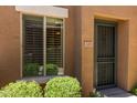 Charming townhouse entrance with a security door, desert landscaping and nearby window at 7726 E Baseline Rd # 125, Mesa, AZ 85209