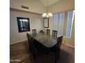 Formal dining room with dark wood table, matching chairs, and modern light fixture at 1032 E Sheffield Ave, Chandler, AZ 85225