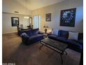 Spacious living room with plush blue sofas and dark coffee table, adjacent to dining area at 1032 E Sheffield Ave, Chandler, AZ 85225
