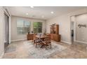Bright dining room with a wooden table and chairs, complemented by natural light and stylish decor at 10412 W Cottontail Ln, Peoria, AZ 85383