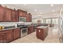 Modern kitchen featuring dark cabinetry, stainless steel appliances, granite countertops, and a center island at 10412 W Cottontail Ln, Peoria, AZ 85383