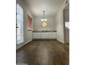Bright living room with hardwood floors, white cabinets, and a decorative light fixture at 10828 N Biltmore Dr # 133, Phoenix, AZ 85029