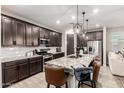 Open kitchen features stainless steel appliances, an island with seating, and dark wood cabinets at 14481 W Via Del Oro --, Surprise, AZ 85379