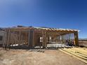 View of the construction showing the wood framing of a modern home with a concrete foundation and blue sky at 16189 W Bajada Rd, Surprise, AZ 85387