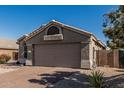 Charming single-story home featuring a brick driveway and low-maintenance desert landscaping at 18297 W Spencer Dr, Surprise, AZ 85374