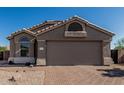 Charming single-story home featuring a brick driveway and low-maintenance desert landscaping at 18297 W Spencer Dr, Surprise, AZ 85374