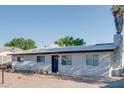 Low angle view of the front of the house with xeriscaped yard and blue door at 217 E Bruce Ave, Gilbert, AZ 85234