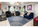 Cozy living room featuring a beautiful area rug, tile floors, and well-lit windows at 2221 W Mitchell Dr, Phoenix, AZ 85015