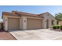 Exterior of home featuring a tile roof, a three-car garage, and desert landscaping at 259 E Montego Dr, Casa Grande, AZ 85122