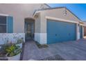 Home exterior showcasing a covered front porch, blue garage door, and desert landscaping at 32729 N Mach Ln, San Tan Valley, AZ 85143