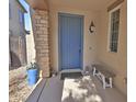 Inviting front porch with stone pillar, a light blue door, bench, and potted plants at 3581 S Arizona Pl, Chandler, AZ 85286