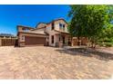 Charming two-story house with a paver driveway, a two-car garage, and a covered porch at 4277 N 180Th Ln, Goodyear, AZ 85395