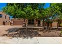 Two-story house with paver driveway, covered porch, and a two-car garage, shaded by mature trees at 4277 N 180Th Ln, Goodyear, AZ 85395