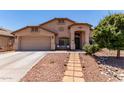 Single-story home boasts well-maintained landscaping, a two-car garage, and excellent curb appeal at 44853 W Jack Rabbit Trl, Maricopa, AZ 85139