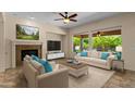 Bright and airy living room featuring a fireplace, large windows, and comfortable seating at 4528 E Donato Dr, Gilbert, AZ 85298