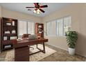 Well-lit home office with a wooden desk, ample storage, and plantation shutters at 4528 E Donato Dr, Gilbert, AZ 85298