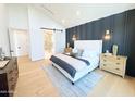 Bright bedroom with vaulted ceilings, decorative headboard, ensuite bathroom and light wood floors at 8038 E Clarendon Ave, Scottsdale, AZ 85251