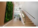 Grand foyer featuring modern stairs, a striking green wall installation, and an elegant chandelier at 8038 E Clarendon Ave, Scottsdale, AZ 85251