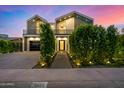 Beautiful two-story modern home with professional landscaping, a black framed garage, and stylish design at 8038 E Clarendon Ave, Scottsdale, AZ 85251