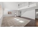 Bright, open living room with plush carpet, hardwood floors, and a high ceiling at 9051 W Iona Way, Peoria, AZ 85383