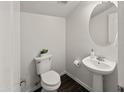 Cozy powder room with pedestal sink, decorative mirror, and modern toilet at 9051 W Iona Way, Peoria, AZ 85383