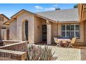 Charming single story home featuring desert landscaping and a beautiful wrought iron door at 9839 W Utopia Rd, Peoria, AZ 85382